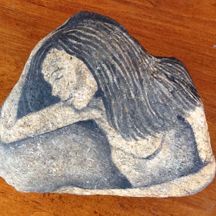 Rock painting of a woman holding her head.