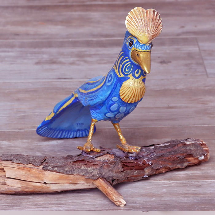 Sculpture of a small Tropical Bird perching on a branch.